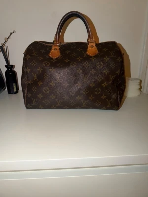 Louis Vuitton speedy 30 - Säljer min Louis Vuitton speedy i storlek 30. Säljer då den inte kommer till användning längre. Väskan är i jättefint skick, kan förekomma små defekter med tanke på att den är vintage. Dragkedjan är i jättebra skick utöver att själva dragkedje hänget har gått av. Handtagen är också i jättefint skick! Pris kan diskuteras. Skriv vid frågor och funderingar!💗