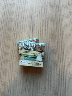 Balm Desert bronzer från theBalm - Säljer en Balm Desert bronzer från theBalm i en kompakt förpackning med spegel. Färgen är en varm, matt brun ton som ger en solkysst look. Förpackningen har en retrodesign med illustration och är gjord av kartong. Mer än halva kvar nästan.