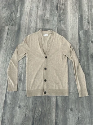 Beige cardigan från Jack and jones - Stilren beige cardigan från Jack and Jones. Passar mig och jag är 180cm. Nytt skick, hör av er vid frågor🙌