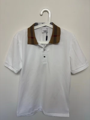 Vit burberry piké slimfit  - Vit burberry piké i slimfit modell, perfekt nu till sommaren | Storlek Medium | Fraktar samma dag om köp sker innan 22:00