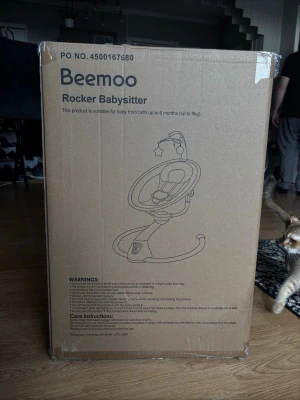 Beemoo Rocker Babysitter - Säljer en Beemoo Rocker Babysitter för bebisar upp till 6 månader (max 9 kg). Babysittern har en modern design med mjuka former och är utrustad med sele och leksaksbåge. Perfekt för att vagga och underhålla små barn hemma.Den är elektronis och är knappt använd.den var köpt för 1200kr