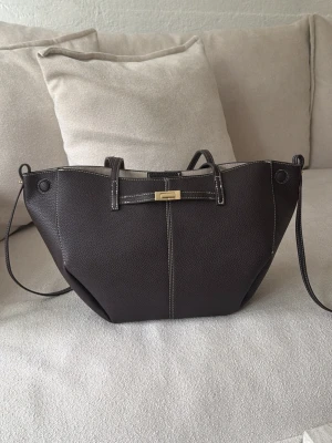 Mörkbrun shoppingväska i läderlook - Den lilla väskan från Gina. Super fin jätte bra skick bara använt en gång..köparen står för frakten