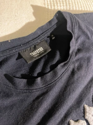 Trapstar svart set med tryck - Säljer ett svart set från Trapstar med matchande tröja och byxor. perfekta setet för dig till sommaren! Tvättas och fixas för er innan de kommer, va inte rädd att fråga!