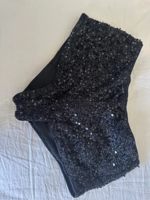 Festliga paljett shorts  - Korta svarta paljett shorts perfekta för fest eller konsert. Kjedja på sidan. 