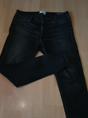 Svarta Dondup jeans - Snygga svarta dondup jeans med klassisk femficksdesign och diskreta slitningar. Jeansen har smal passform och normal midja, perfekta till en avslappnad stil. Materialet är stretchigt för extra komfort. Nypris: 3500kr / Mitt pris: 799kr