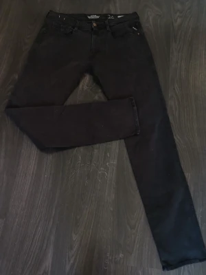 Svarta slim fit jeans från Replay Anbass - Säljer ett par svarta populära Replay Anbass jeans i herrmodell. De har en slim passform med klassisk femficksdesign och snygga detaljer på bakfickan. Jeansen är tillverkade i stretchigt bomullsmaterial för extra komfort och har en stilren look som funkar till många outfits. W34, L34. Nypris: 849kr / Mitt pris: 299kr