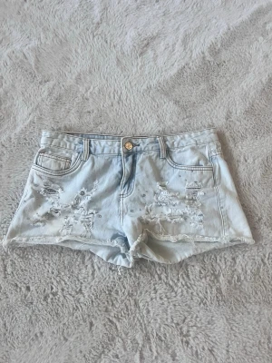 Ljusblå jeanshorts med stenar  - Super fina jeansshorts i storlek 38 men skulle dock säga att dom är mer storlek 36 💗 