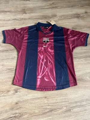Barça x Cactus Jack matchtröja - Säljer en limited edition FC Barcelona x Cactus Jack matchtröja från Nike. Tröjan är vinröd och marinblå med klubbmärke och Nike-logga på bröstet, samt tryck med nummer 2, 'BARÇA' och Cactus Jack på ryggen. Tillverkad i lätt och ventilerande polyester.