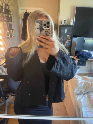 Svart loose jacka i bomull - Säljer en svart jacka i bomull med loose passform. Jackan har knappar framtill och långa ärmar. Enkel och stilren design som passar till det mesta. Perfekt för dig som gillar en avslappnad look.