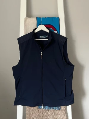 Mörkblå väst från Polo Ralph Lauren - Stilren mörkblå väst från Polo Ralph Lauren. Perfekt till Golf eller i vardagen..