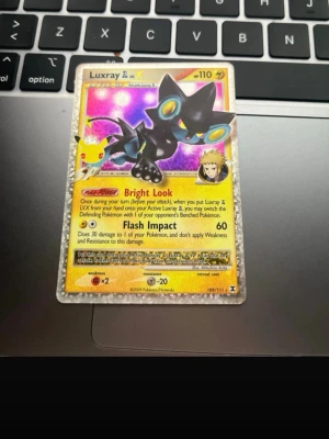 Luxray LV.X Pokémonkort holografiskt - Säljer ett holografiskt Luxray LV.X samlarkort från Pokémon. Kortet har en glittrig guldkant, färgstark illustration med lila och blå bakgrund samt detaljer i gult och svart. Kortet är officiellt från Pokémon och har nummer 109/111.