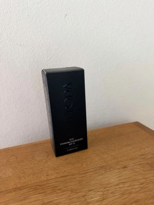 Meroda Mini Changing Foundation SPF 15 - Meroda Mini Changing Foundation SPF 15 kommer i en elegant svart förpackning. Produkten är en flytande foundation som anpassar sig efter hudtonen och ger ett naturligt resultat. Perfekt för dig som vill ha en smidig bas med solskydd.  Den är öppnad och testad en gång. 15ml