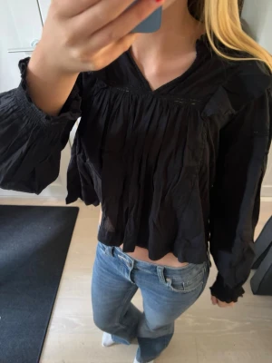 Blus  - Säljer en svart blus med v-ringning och vida, långärmade ärmar. Supé Edin till sommaren nuuu