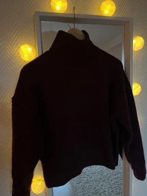 Vinröd polotröja från Zara - Mysig vinröd stickad polotröja från Zara. Tröjan har hög krage och långa ärmar, perfekt för kyliga dagar. Materialet är mjukt och ger en avslappnad men ändå stilren look. Passar perfekt när som!!
