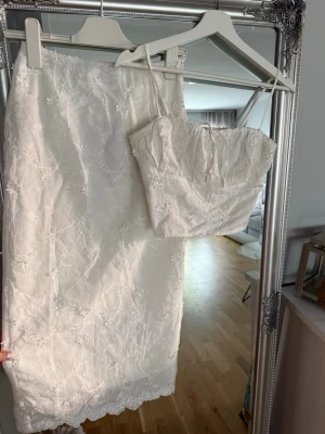 Set Nakd - Jättefint set från Na-kd, inköpt förra året. Kjolen helt ny med lappar & linnet är sparsamt använt. Blomdetaljer och dragkedja vid sidan av både kjolen och linnet. Slit baktill på kjolen