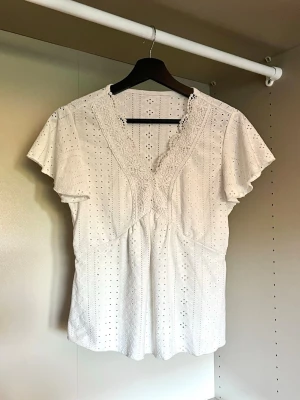 Spets topp - Fin kortärmad topp med broderier.