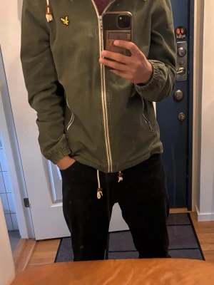 Mörkgrön vindjacka från Lyle & Scott - Säljer denna extremt snygga Lyle scott jacka i färgen mörkgrön då jag tyvärr har tröttnat på den.  Storlek S men skulle säga att den passar även M. Finns även spännen vid halsen och midjan för en schystare passform! 