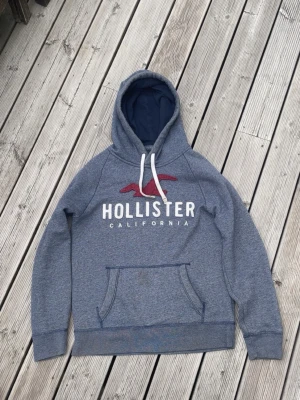 Blå hoodie från Hollister med logga - Säljer en blå hoddie från Hollister i storlek M. Den är i mycket bra sick och har inga defekter. Om man vill ha fler bilder eller frågor så är det bara att höra av sig🙌