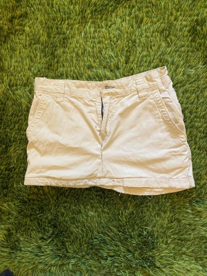 Gant Beige Miniskirt i bomull - Snygg beige miniskirt från Gant i bomull. Kjolen har fickor fram, bälteshällor och två bakfickor med lock och knapp. 