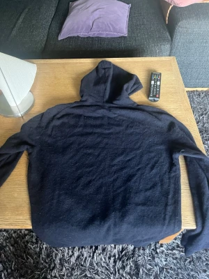 Mörkblå hoodie från Oscar Jacobson - Säljer en mörkblå hoodie från Oscar Jacobson. Hoodien är helt intakt och har inga skador. Den är i storlek M.