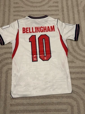 England 2026 #10 Bellingham - Replika England tröja helt ny med tags med Bellingham på ryggen. För fler bilder eller frågor tveka inte att skriva i dm. Fler tröjor i profilen. Se bio för tvättråd