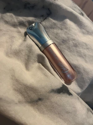 Milky lipgloss i skimrande nude - Säljer ett lipgloss från Glam of Sweden i färgen 06. Läppglanset har en skimrande nude-nyans med metallisk finish och kommer i en smidig tub med silverfärgat lock. Perfekt för dig som vill ha glansiga och fylliga läppar.