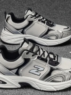 Silvriga sneakers med svart detalj - Stilrena sneakers i silver och svart med meshpaneler och syntetdetaljer. Skorna har en chunky vit sula och svarta snören. Sidopanelen pryds av ett Z-logotyp. Perfekta för en sportig och trendig look.