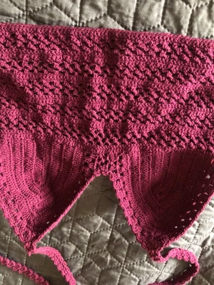 Virkad mörkrosa/lila croppad ltopp med snörning - Handgjord virkad linnetopp i mörkrosa/lila med snyggt hålmönster och knytband. Toppen är croppad och har trekantsformade kupor, perfekt för sommardagar. Materialet känns mjukt och luftigt mot huden.