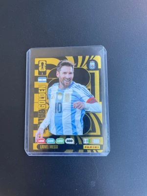 Panini Golden Ball fotbollskort Messi - Unikt Panini Golden Ball samlarkort med Lionel Messi i argentinska landslagströjan. Kortet har svart och guld design med holografiska detaljer och ligger i ett plastfodral. Perfekt för dig som samlar på fotbollskort eller gillar Messi. Vanliga priset ligger runt 650 dollar = ca 6500kr. Pris kan diskuteras 