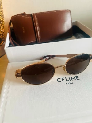 Celine ovala solglasögon guld/brun - Snygga ovala solglasögon från Celine med guldfärgade metallbågar och bruna glas.  Allt kommer i originalförpackning.                                Köpte i Stockholm 2025  Nypris: 5650 kr