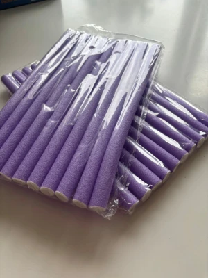  böjbara hårspolar - Säljer ett paket med lila mjuka böjbara hårspolar som är perfekta för att skapa lockar utan värme. Spolarna är tillverkade i skumgummi med vita ändar och är lätta att använda för olika frisyrer. Perfekt för dig som vill fixa snygga lockar hemma.