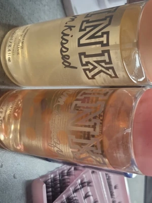 Victoria's Secret PINK body mist duo - Två fräscha body mists från Victoria's Secret PINK-serie. Ena heter 'Sun Kissed' och har en ljusgul ton, den andra har en persikofärgad nyans och heter 'Warm & Cozy'. Båda kommer i genomskinliga plastflaskor med rosa lock och rymmer 250 ml vardera.