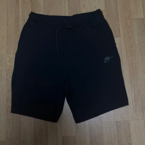 Nike Tech Fleece shorts - Size S - Shortsen är i mycket bra skick. Inga synliga skador eller slitage (en del av snöret på ena sidan är klippt).  Bekväm och klassisk Tech Fleece shorts som passar perfekt till både vardag och träning. Size: S    🏷️ Rabatt vid köp av flera plagg!