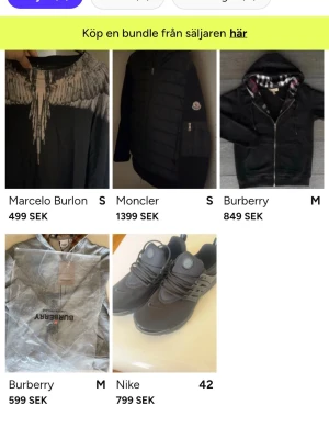 Nya konto in o checka - Snygg svart t-shirt från Marcelo Burlon med unikt tryck i vitt och grått runt halsen som liknar fjädrar. T-shirten har korta ärmar och en normal passform. Perfekt för dig som vill sticka ut med en cool design.