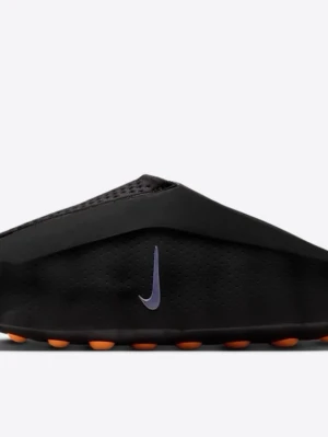 Svarta Nike tofflor med orange sula - Säljer ett par svarta tofflor från Nike med en stilren, futuristisk design. Tofflorna har en perforerad ovandel, lila Nike-logga på sidan och en unik sula med orange detaljer undertill. Tillverkade i syntetmaterial för en modern look.