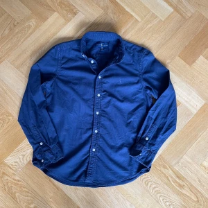 Mörkblå skjorta från Ralph Lauren - Säljer en snygg mörkblå skjorta från Ralph Lauren i storlek Xs. Skicket är 8/10 inga defekter. Nypris ligger på 1600 kr mitt pris 299 kr. Pris kan diskuteras