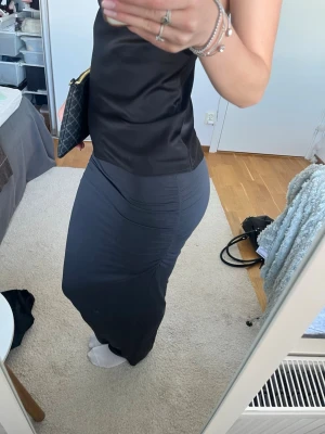 Mörkgrå maxi kjol från Gina tricot - Snygg mörkgrå långkjol med tight passform och strunch i sidan. Finns ett litet hål (se bild) annars inga skador. Skriv vid frågor och pris kan diskuteras! 💞