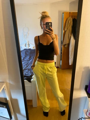 Gula mjukisbyxor från juicy couture  - Säljer ett par ljusgula mjukisbyxor med dragsko i midjan och två sidofickor. Byxorna har en avslappnad passform och är perfekta för chill dagar. Tillverkade i mjukt material som känns skönt mot huden.