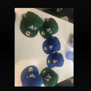 New Era MLB kepsar Oakland & LA - (Värde 500kr+ styck i ny pris (500x6=3 000kr i total )) äSäljer flera New Era MLB kepsar i klassisk snapback-modell. Finns i grönt med Oakland A's-logga och blått med LA Dodgers-logga. Broderad text 'Love & Hustle = Game' på sidan och officiella MLB-märket bak. Materialet är bomull och polyester.