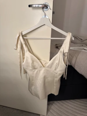 Zara satin topp med rosetter  - Säljer då den inte kommer till användning. Super super fin topp i champagne färgat satin likande material! Använd en gång🤗