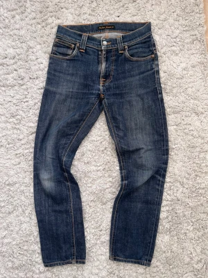Mörkblå jeans från Nudie Jeans - De är i superbra skick och har otrolig snygg tvätt/fades. Storlek W28 L32! Rätt säker på att den är grim Tims!