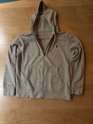 Polo Ralph Lauren zip hoodie - Säljer min ljusgråa Ralph Lauren hoodie med dragkedja. Klassisk modell som passar till allt och sitter jättesnyggt! Den ikoniska loggan är broderad i mörkblå på bröstet.                                                 Storlek: S  Skick: 9/10 (Väldigt fint skick)  Färg: Ljusgrå.  Fraktar så snabbt som möjligt ! Skriv om du har frågor eller vill ha fler bilder. 