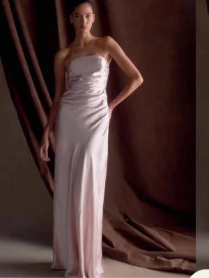 Ljusrosa axelbandslös långklänning - Elegant ljusrosa långklänning med axelbandslös design och figurnära passform. Helt ny med prislapp! Perfekt för bal🩷