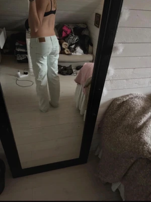 Ljusblå raka jeans - Säljer ett par ljusblå jeans med raka ben och klassisk femficksmodell. Jeansen har en brun läderpatch bak i midjan och är tillverkade i denim. Perfekta för en avslappnad och trendig stil. Midjemått - 39 cm, innerbenslängd - 76 cm