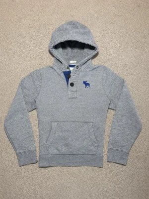 Abercrombie & Fitch Hoodie med Knappar  - Snygg grå Hoodie med knappar från Abercrombie & Fitch - Produkten är i utmärkt och fräscht skick - Storlek: L men sitter som M - Pris: 599 kr - Först till Kvarn! 