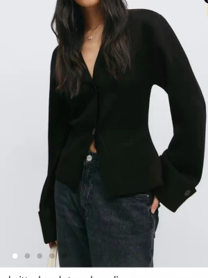 Svart kofta med vida ärmar - Stilren svart kofta med knappar framtill och breda, vida ärmar. Förliten på mig💓använt engång 