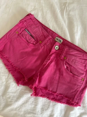 Rosa jeansshorts  - Snygga rosa jeansshorts från Tommy Hilfiger!! W27🥰midjemått rakt över är ca 35cm💕💕 super snygg färg!!!
