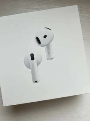 Apple AirPods 4  - Säljer ett par vita Apple AirPods 4 med aktiv brusreducering. Trådlösa hörlurar med laddningsetui, kompatibla med USB-C, Apple Watch och Qi-certifierade laddare. Snygg och stilren design i plast, perfekt för musik och samtal. Helt nya