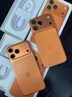Iphone 17 pro max  - Snygg orange iPhone 17 PRO Max med stilren design och trippelkamera på baksidan. Mobilen har rundade hörn, glasbaksida och metallram. Apple-loggan syns tydligt på baksidan och laddkabel medföljer i förpackningen.