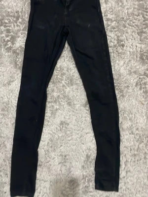 Svarta jeans med smal passform - Säljer ett par svarta jeans med smal passform och stretchigt material. De har en enkel design utan synliga detaljer och är perfekta för dig som gillar en clean och stilren look. Passar till det mesta och är superbekväma.